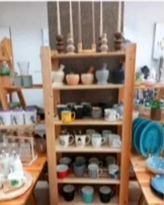 Κούπες και κεραμικά σε ξύλινη ραφιέρα